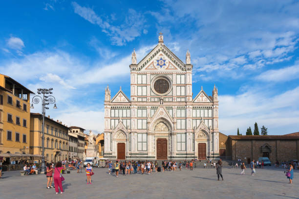 Tourists in front of Basilica di Santa Croce (Basilica of the Holy Cross), a franciscan church completed in 1385. Located on Piazza di Santa Croce, a city square in central Florence, Italy.