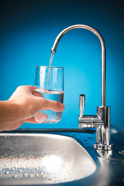istock hand pouring a glass from water filter tap 918266880