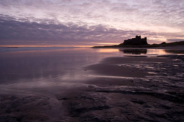 バンバラ城 - bamburgh castle northumberland england dawn north sea ストックフォトと画像