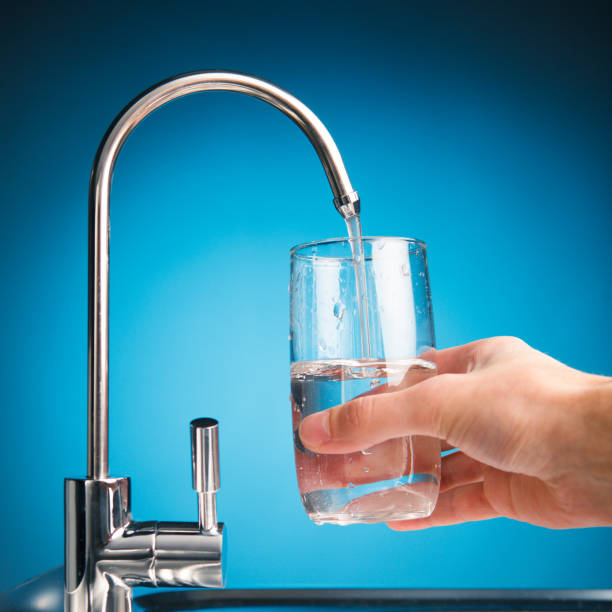 istock hand pouring a glass from water filter tap 918266966