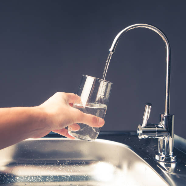 istock hand pouring a glass from water filter tap 918266996