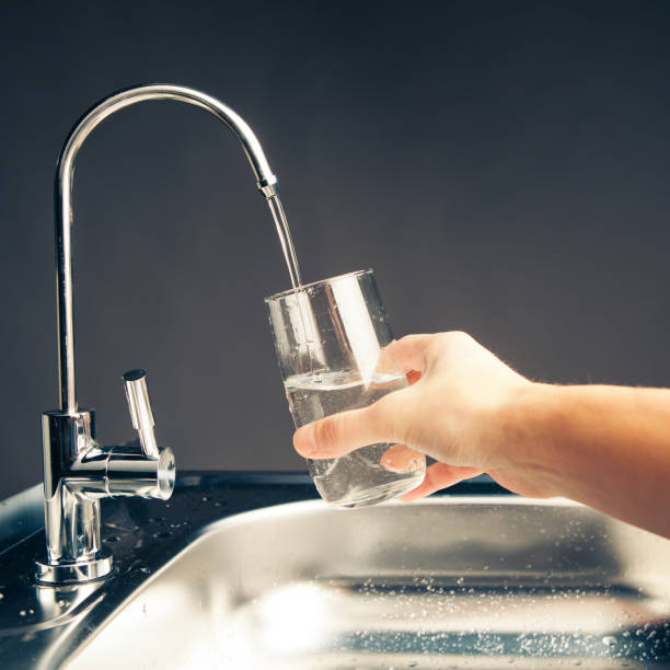 istock hand pouring a glass from water filter tap 918267038
