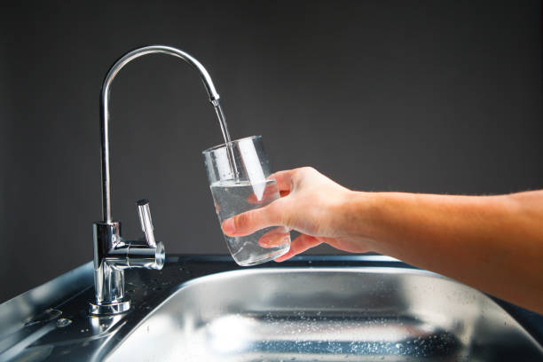 istock hand pouring a glass from water filter tap 918267094