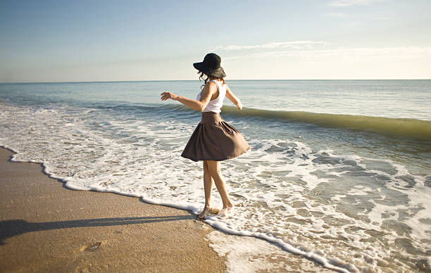 Woman dancing in the ocean wake stock photo