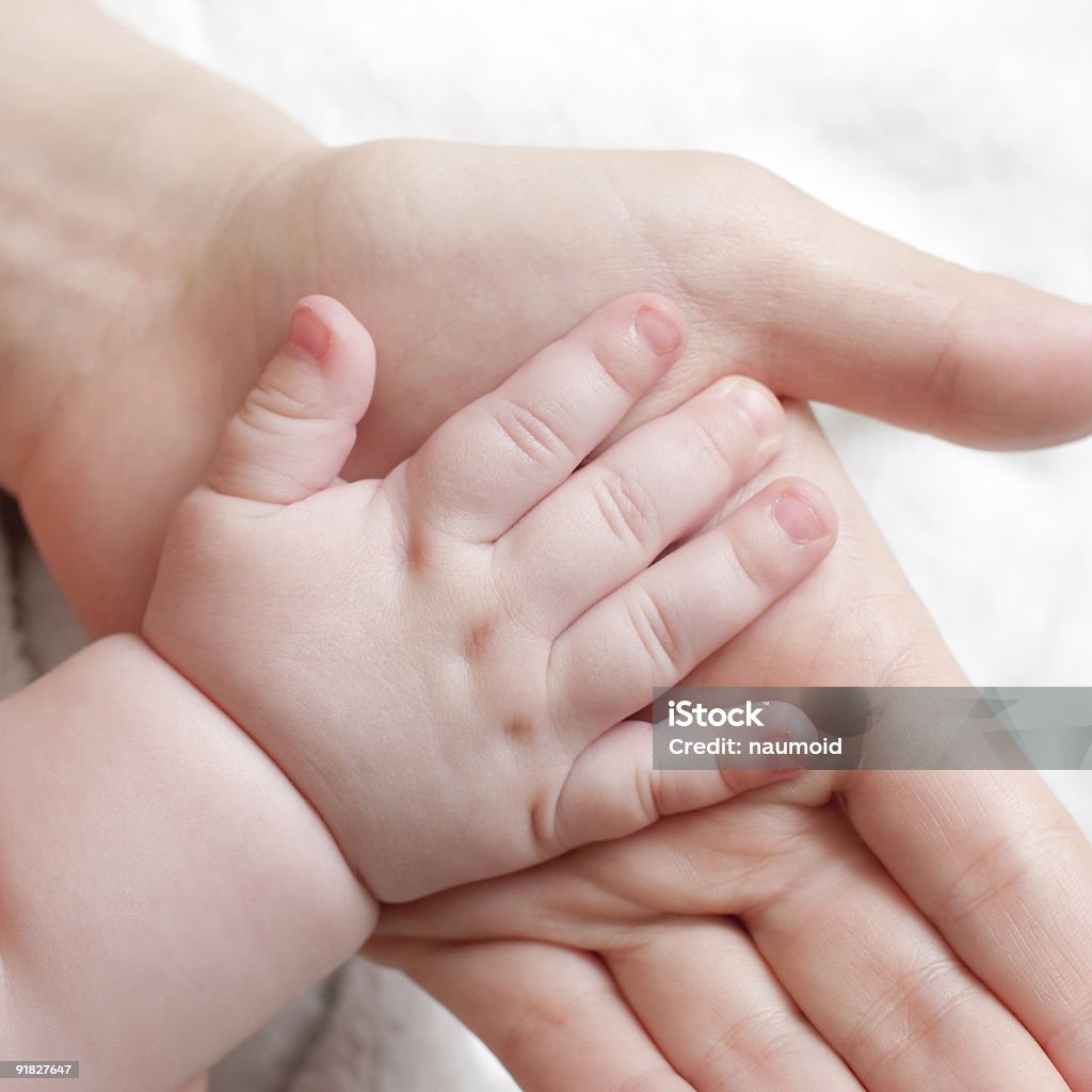 A mother and daughter touch hands for the first time Beauty Mother holding her child's hand Adult Stock Photo