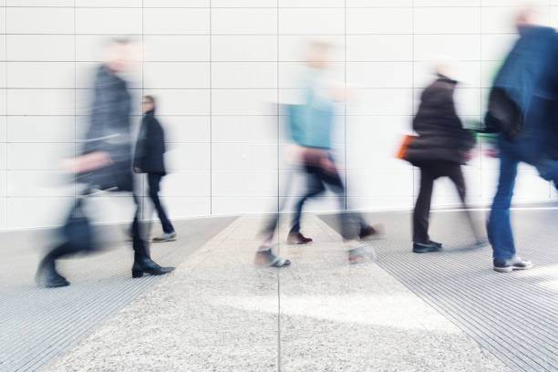 blurred people in a corridor blurred people walking in a corridor defocused office business motion stock pictures, royalty-free photos & images