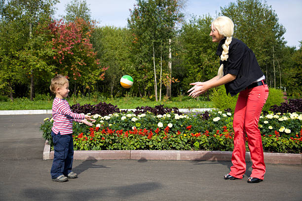 istock Mother and her son playing with ball in summer day 91827965
