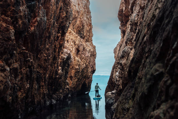 Man paddleboarding out of the narrow canyon