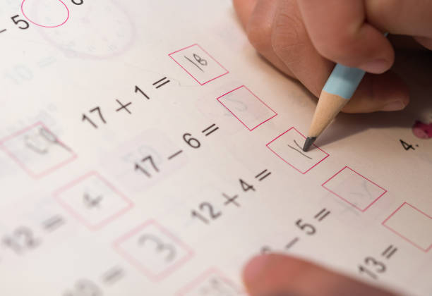 kid doing homework of simple subtraction and addition