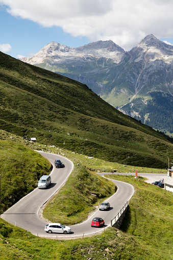 Aerial view of Spluegenpass, group of cars speeding on alpine road, serpentines road, Swiss Alps and landscape, Switzerland