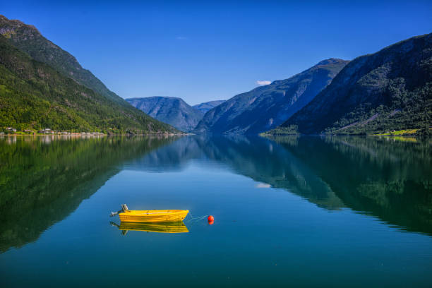 istock Fishing boat sailing on water with mountains in Norway 918289686