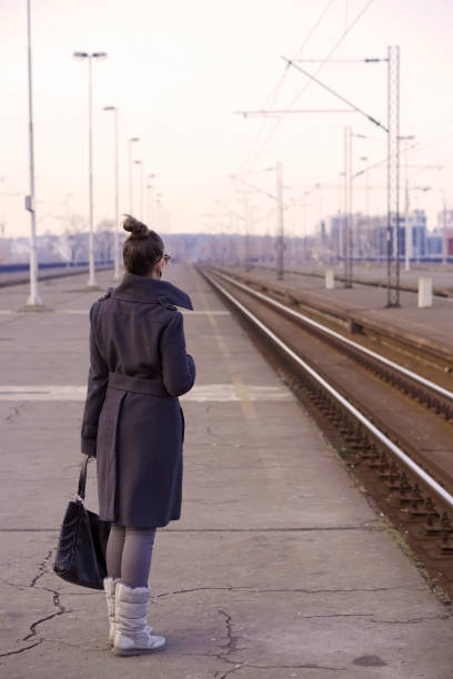 istock Young woman on a railroad station using a smart phone 918293064