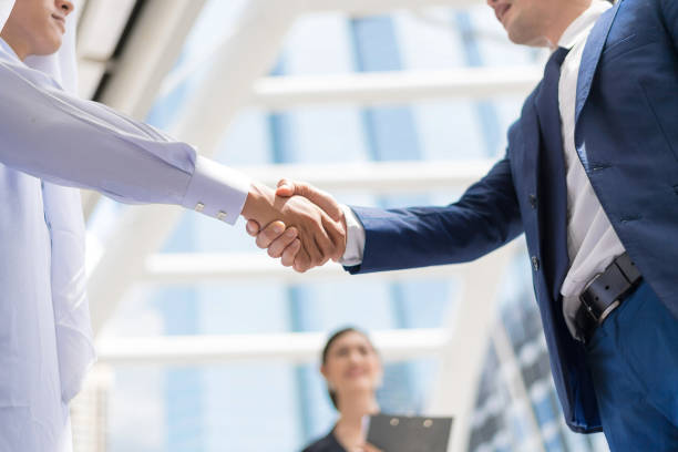 istock Businessmen join hands after agreeing to work together. 918297498