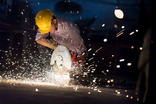 istock In selective focus and motion blur with Low light image of Worker Use Electric Angle Grinders metal  in Factory and throwing many sharp sparks. 918297580