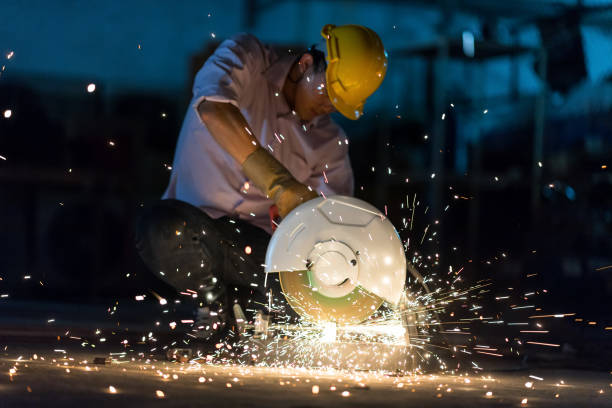istock In selective focus and motion blur with Low light image of Worker Use Electric Angle Grinders metal  in Factory and throwing many sharp sparks. 918297678