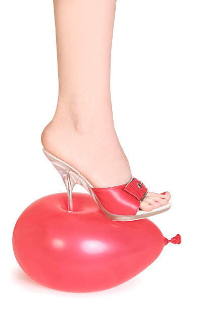 red balloon under spike heel stock photo