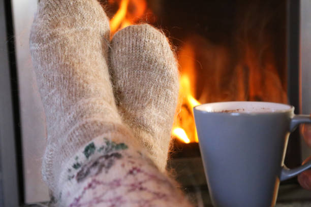 istock Feet in wool socks warming at the fireplace 918303882
