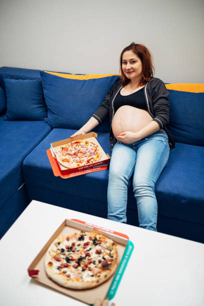 istock Young pregnant woman holding pizza 918303982