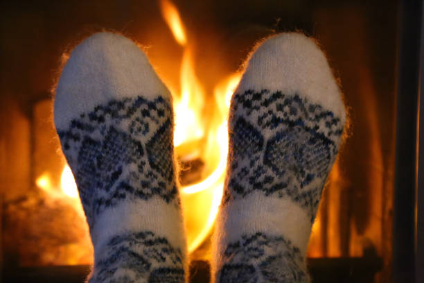 istock Feet in wool socks warming at the fireplace 918304102