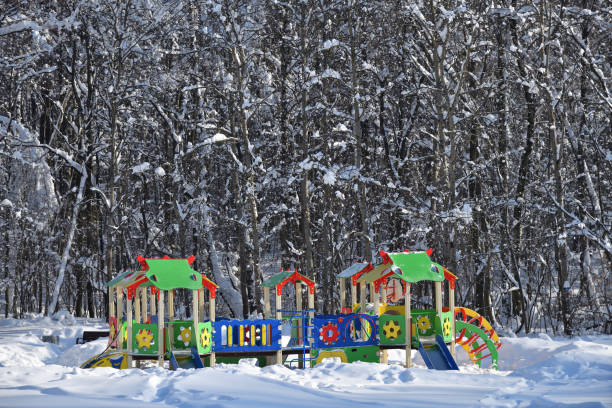 Public's playground in the city of Moscow. Bright colorful empty children's playground in the winter yard of a city park forest. The concept of city improvement taking care of children walking outdoors in any weather