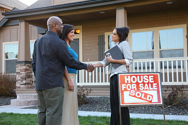 Couple shakes hands with Real Estate Agent outside new house  real estate broker stock pictures, royalty-free photos & images