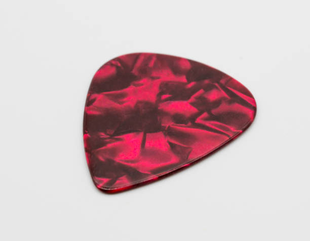 istock Dark red plastic guitar plectrum isolated on white background. Guitar Picks 918315416