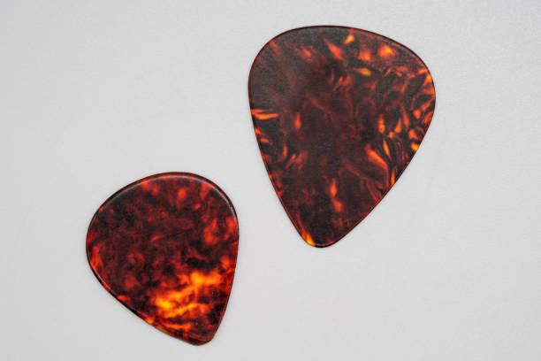 istock Two different sizes of brown plastic guitar plectrum isolated on white background. Guitar Picks 918315436