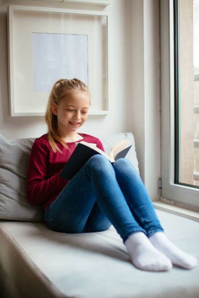 istock Beautiful young girl reading a book 918315514