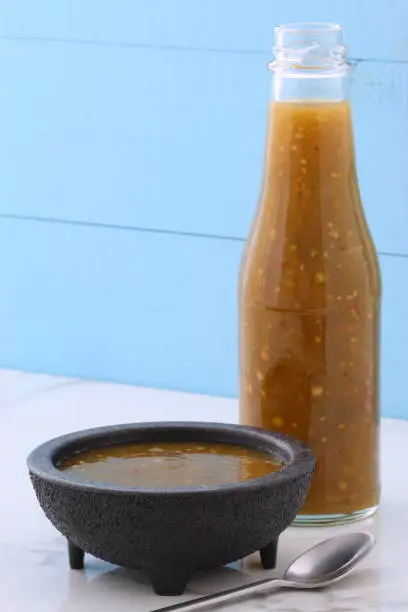 Artisan mexican tomatillo sauce on retro vintage carrara marble setting, with a spicey mild hot flavor perfect for all your Mexican, tex-mex recipes and sides.