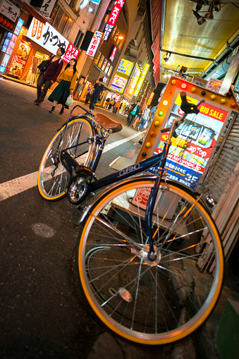 Tokyo, Japan - October 1, 2017. Bicycle parked while pedestrians walk by in the Akihabara District of Tokyo the capital of Japan.