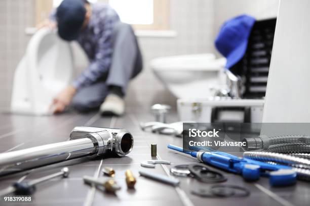Plumber At Work In A Bathroom Plumbing Repair Service Assemble And Install Concept Stock Photo - Download Image Now