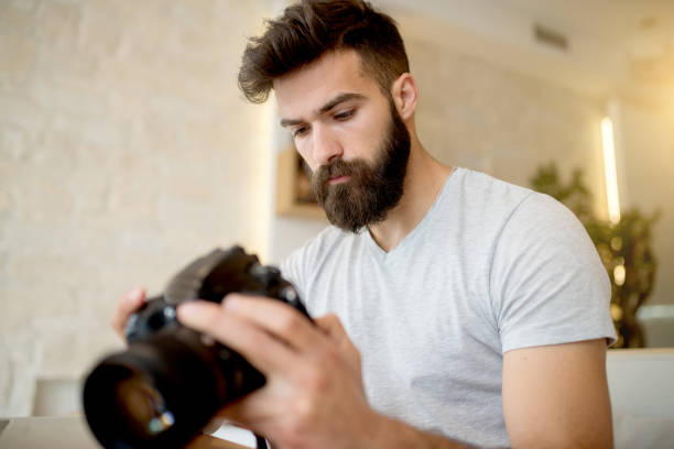 istock Young photographer adjusting settings on his camera. Preparing for photo shooting. 918321564
