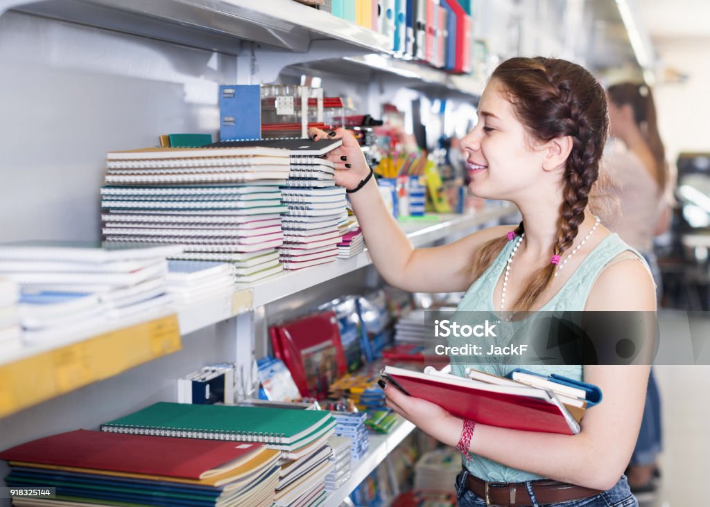 teenager buying different products in stationery shop Cheerful italian teenager buying different products in stationery shop School Supplies Stock Photo