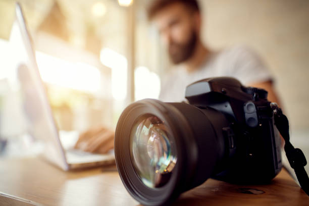 fotograf sprawdzając swoje pliki, od ładowania na laptopie. dziennikarz biurowy. - professional photographer zdjęcia i obrazy z banku zdjęć