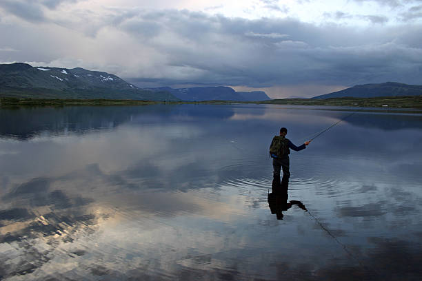 Flyfishing in water surrounded by mountains Flyfishing in the Norwegian mountains near Hemsedal østfold stock pictures, royalty-free photos & images