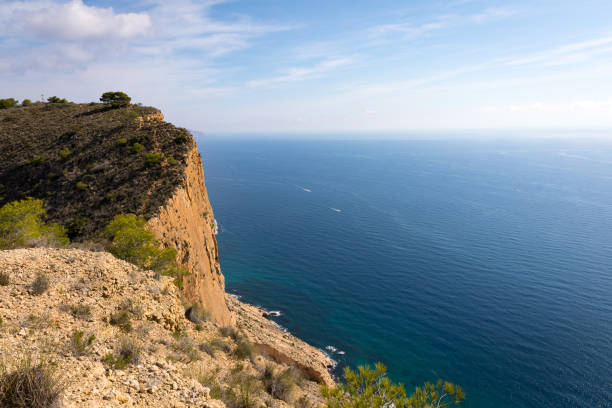 scogliera con oceano blu - benidorm alicante spain headland foto e immagini stock