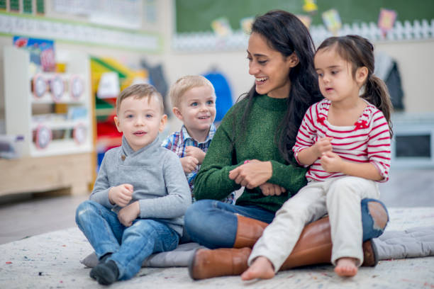 istock Kids Sitting With Teacher 918335892
