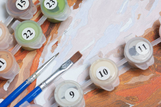 istock Painting on canvas by numbers. Numbered containers with paints and brushes lie on the canvas background. 918342880