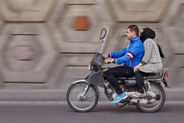 Tehran, Iran - April 28, 2017: Panning motorbike with man and woman at speed, to create motion blur in background.