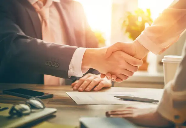 Man and woman are shaking hands in office. Collaborative teamwork.