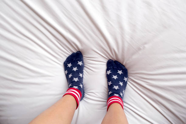 istock woman wearing socks stand on bed. 918358754
