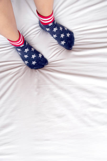 istock woman wearing socks stand on bed. 918358794