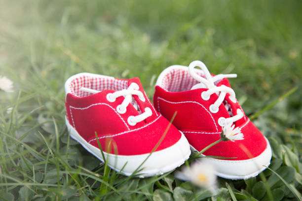istock red baby shoe with green grass background 918364490
