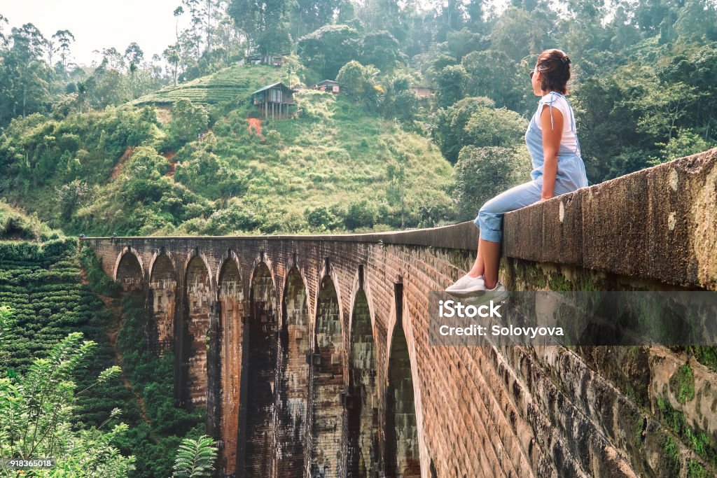 Femme assise sur le pont d’arches neuf Demodara la vue plus visitée de la ville de Ella au Sri Lanka - Photo de Adolescent libre de droits