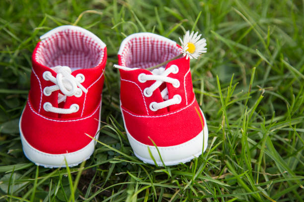 istock red baby shoe with green grass background 918365118