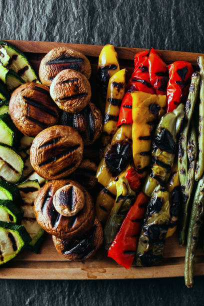 istock grilled vegetables on a wooden tray on a black slate. copy space 918365274