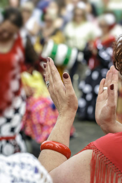 hiszpanka ubrana w flamenco, tańcząca i klaszcząca w dłonie na kwietniowych targach w sewilli. - hiszpanka_& zdjęcia i obrazy z banku zdjęć