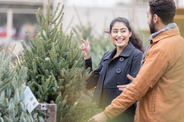 istock Cheerful couple pick out Christmas tree 918377508