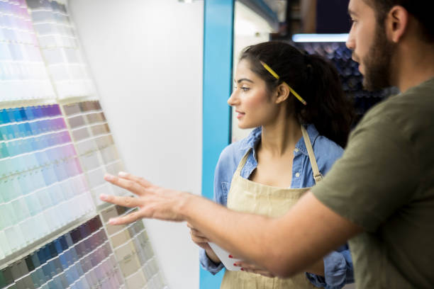 istock Hardware store employee assists customer in paint department 918377528