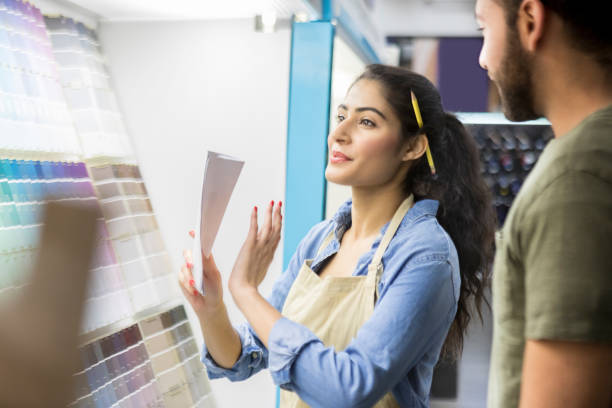 istock Cheerful hardware store employee helps customer pick paint color 918377536